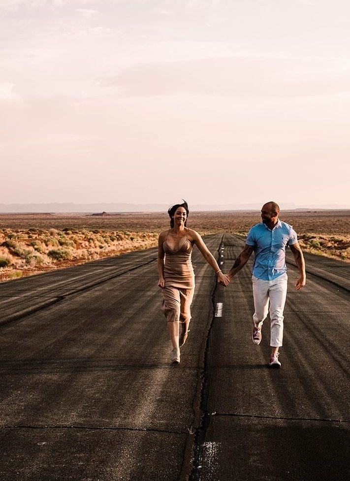 A couple running on the runway at monument valley airport,