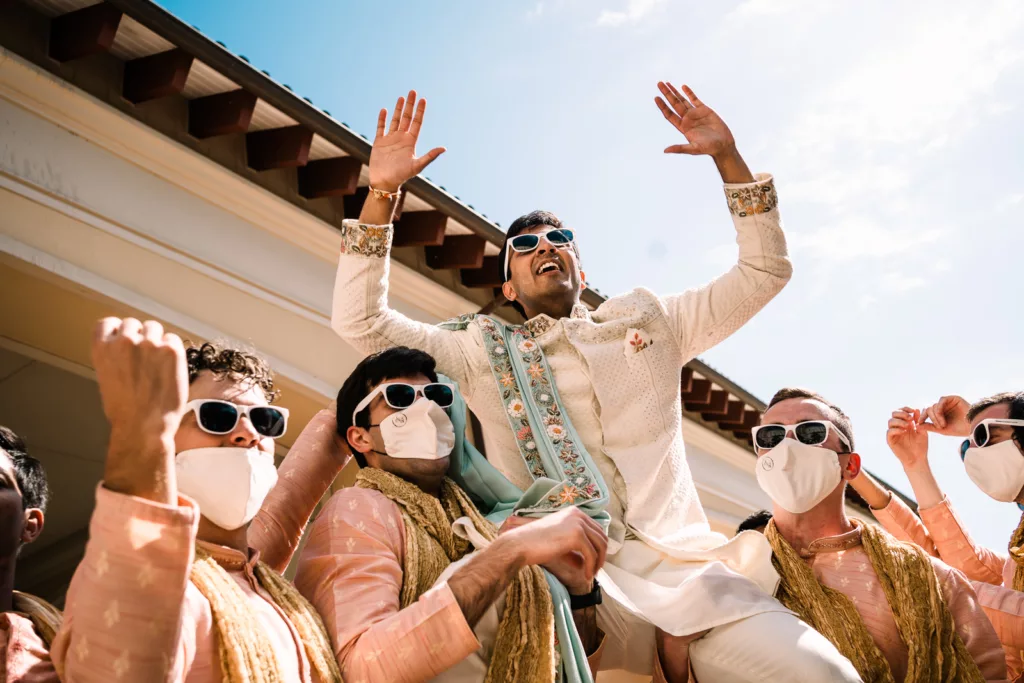 Indian Groom held in the air by groomsmen during the Barat outside of Gaylord Palms.