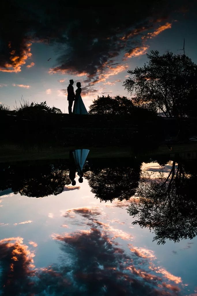 Wedding Experience 1 A unique mirrored reflection of a bride and groom from a pond at a wedding.