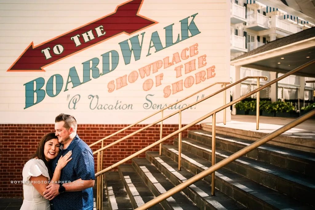 A woman resting her head on a mans chest while standing on the stairs at Disney's Boardwalk Resort, one of the recommended orlando engagement photo locations.
