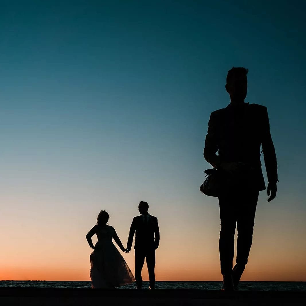 A sunset silhouette of a couple on their wedding day