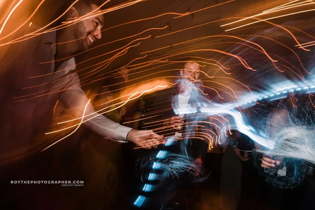 A dynamic scene at a Sunken Gardens wedding reception capturing guests in motion, with streaks of light creating a vibrant and energetic atmosphere.