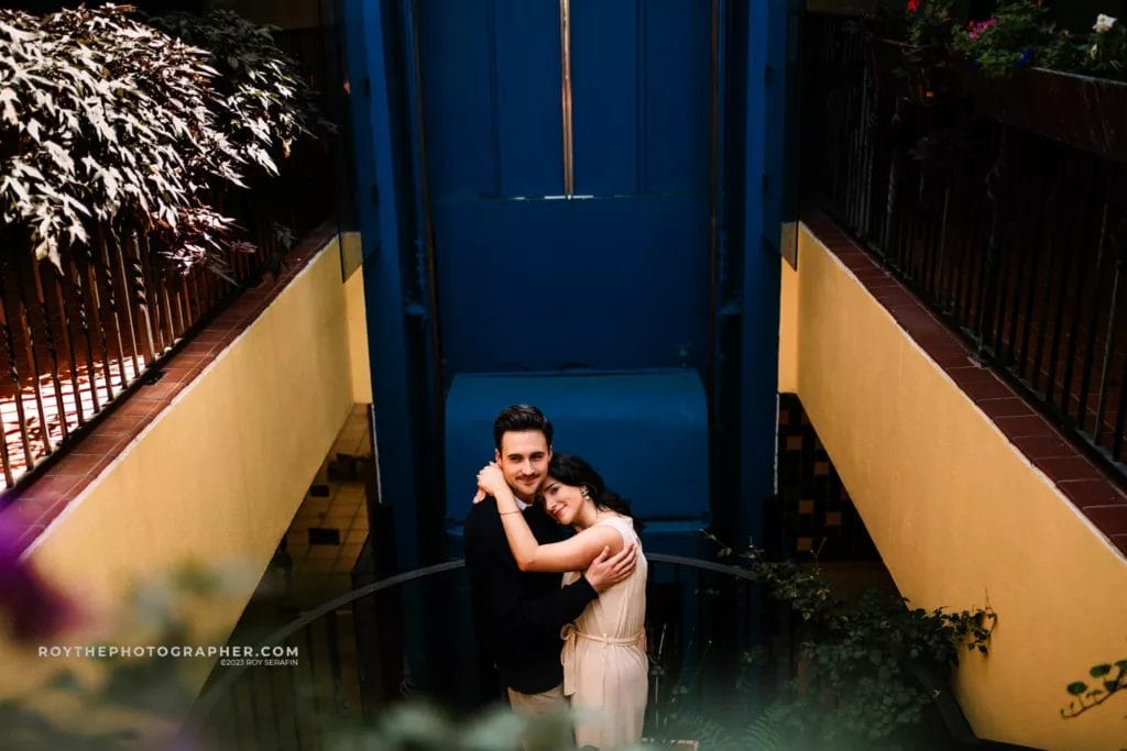 A woman holding a man  on a staircase diuring thier engagement session