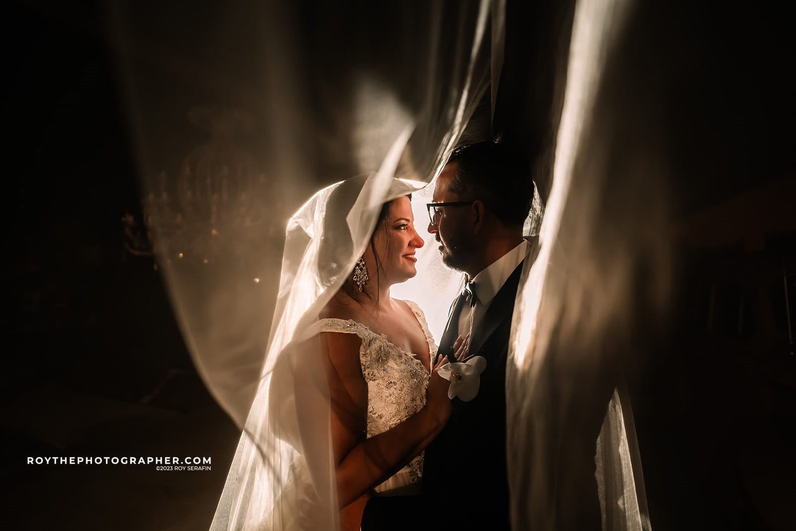 Orlando Wedding Photographer 10 Bride and groom under a veil, romantic lighting.